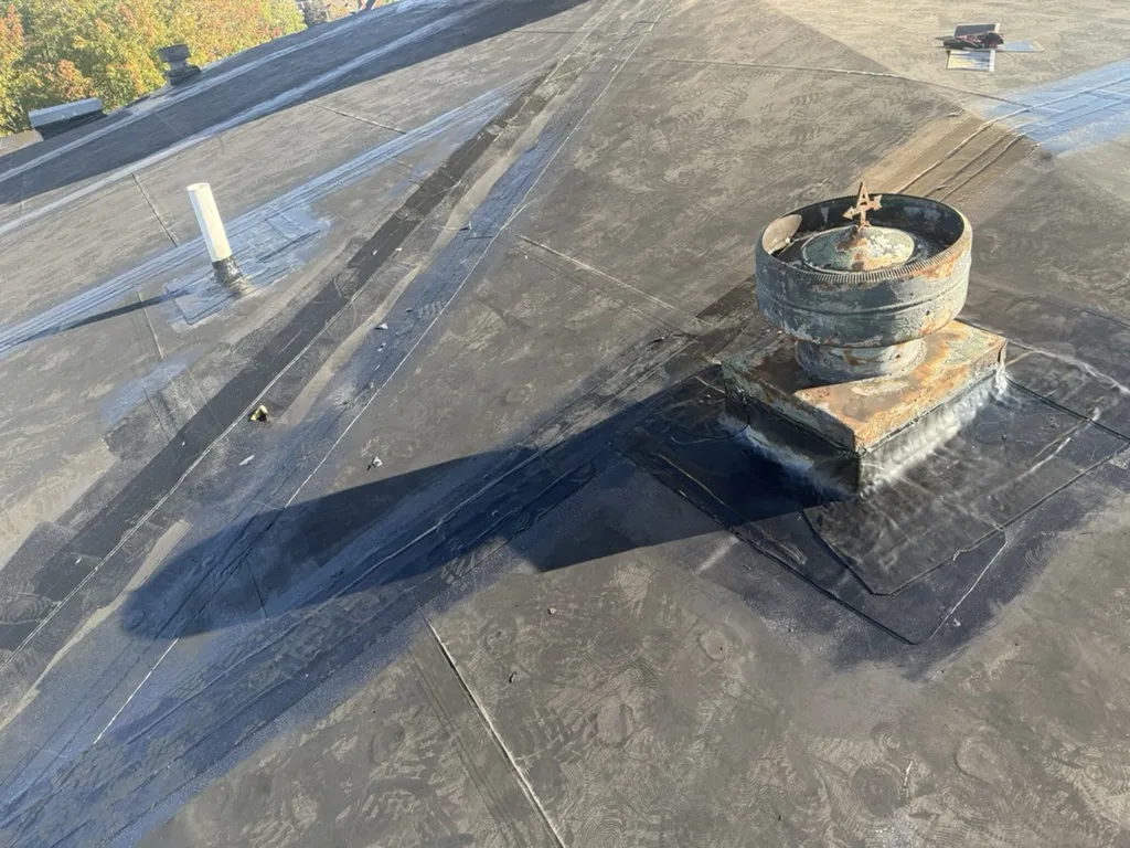 Roof drain area with patch and sealant repair